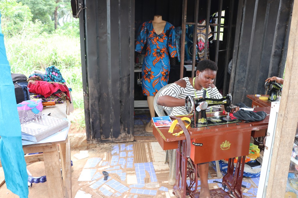 Osamudiamen Queen running stitches on a fabric in her shop