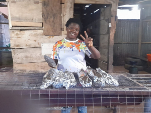 Mercy poses with wrapped barbecued fish